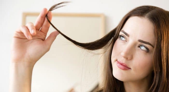 femme jouant avec une des ses mèches de cheveux